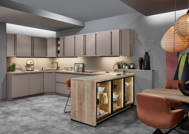 Beige Einbauküche mit Kochinsel, Holzoptik und offenen Regalen, die großzügigen Stauraum und wohnliches Ambiente bietet