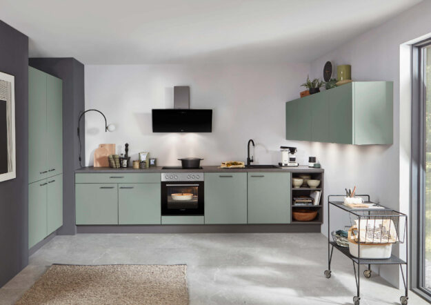 Moderne Küche in Salbeigrün mit Einbaugeräten und offenen Regalen, die minimalistisches Design und praktische Nutzung vereint